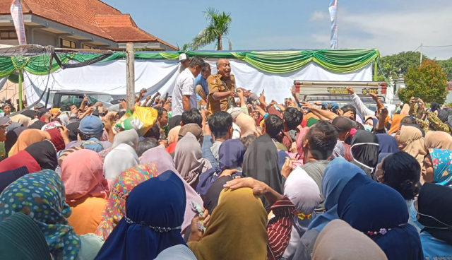Kabid Ketahanan Pangan DKPP Bojonegoro, Moch. Rudianto bermandi keringat melayani kerumunan pembeli beras SPHP di bawah terik matahari.
