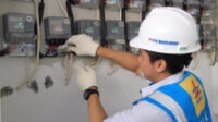 Petugas PLN sedang melakukan pengecekan sambungan listrik.