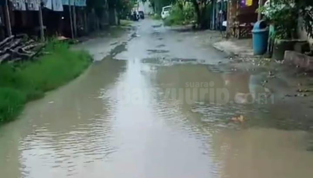 Kondisi Jalan Pondok Pinang yang rusak dan tergenangi air.