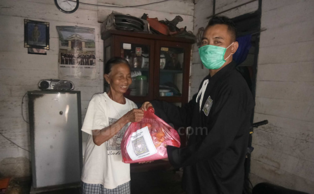 Warga PSHT Rayon Tumbrasanom saat memberikan bansos kepada warga kurang mampu desa setempat.